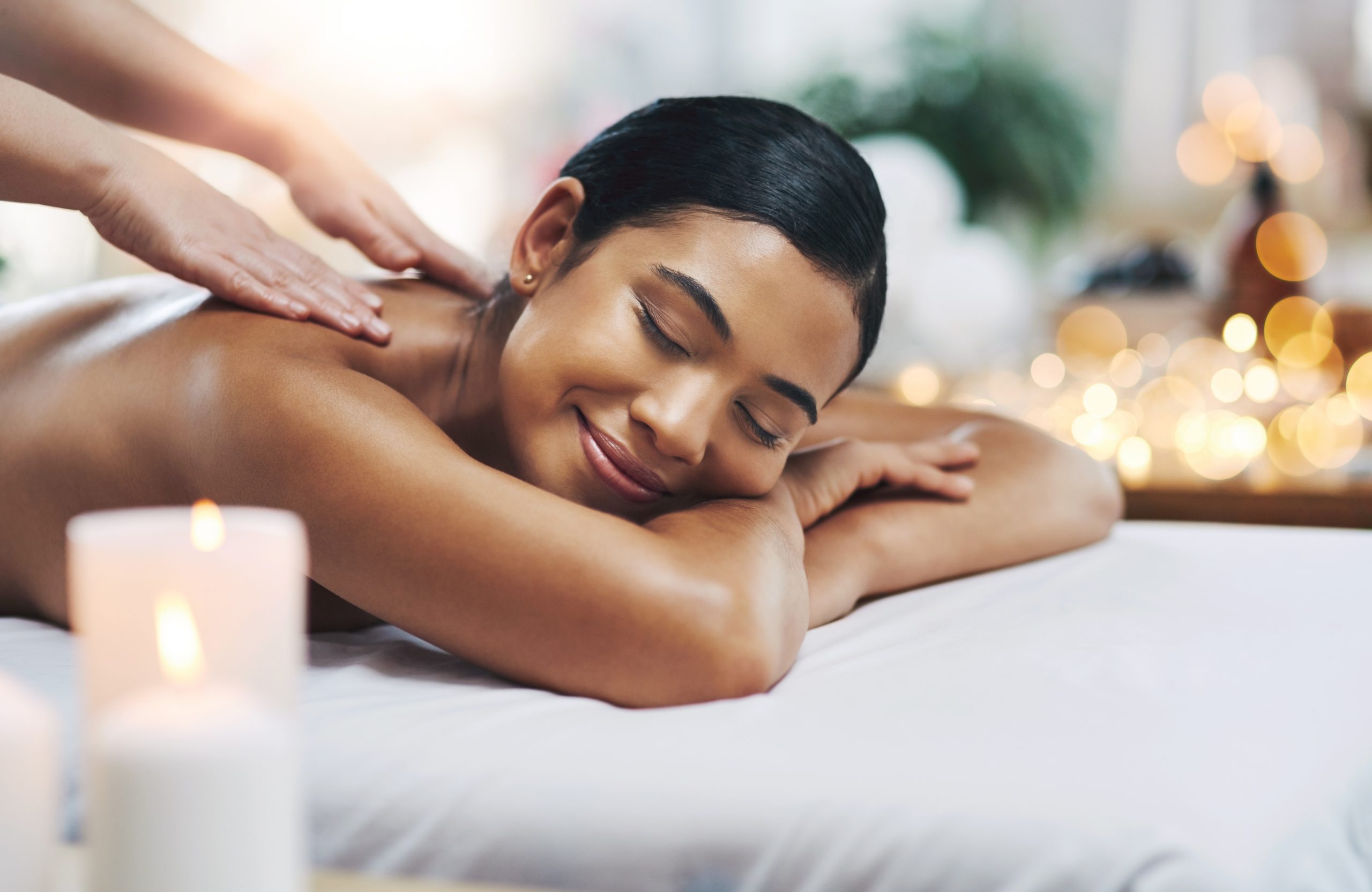 Shot of a relaxed an cheerful young woman getting a massage indoors at a spa.
